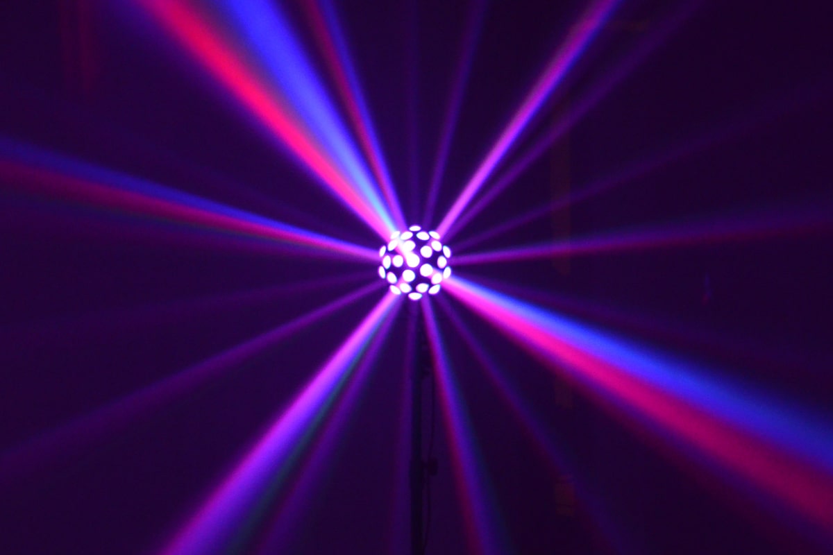 LED Spiegelkugeleffekt strahlt in herrlichen blauen, violetten, roten und rosafarbenen Strahlen